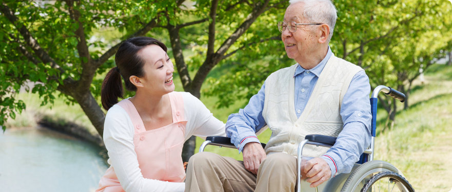caregiver and old man smiling at each other